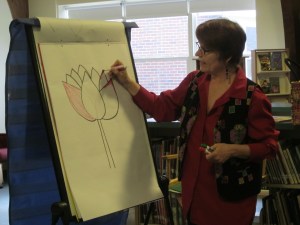 Anne teaching students how to draw a lotus flower, an important symbol in Cambodian culture, at Canal School in Westbrook, ME 
